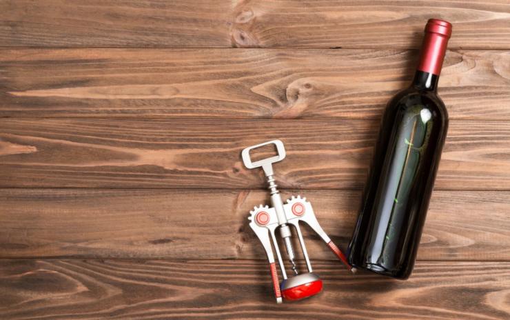 bottiglia di vino e accanto un cavatappi